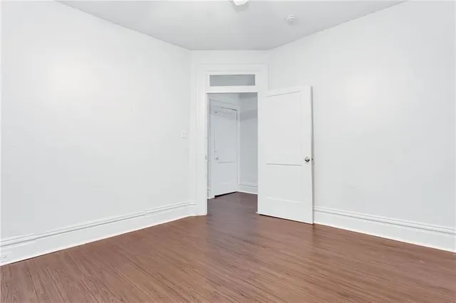 an empty room with wooden floor and closet