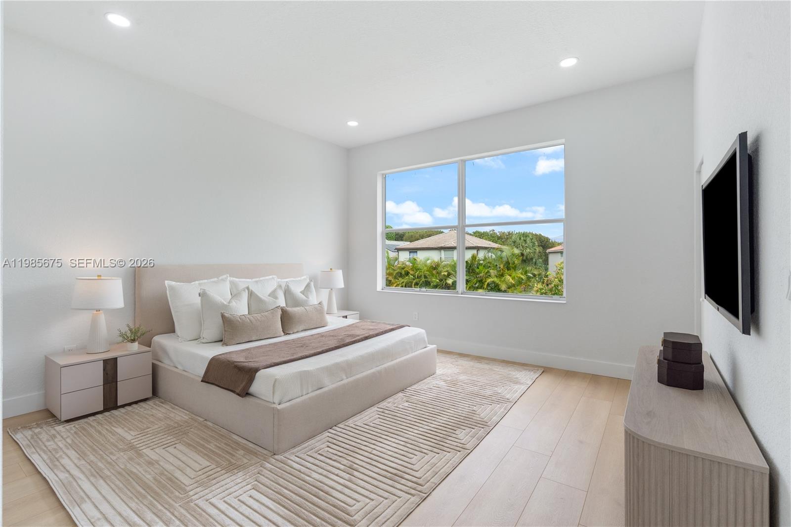 9840 Stover Way Wellington, FL 33414 - Photo 19 of 23 a bedroom with a bed and a flat screen tv