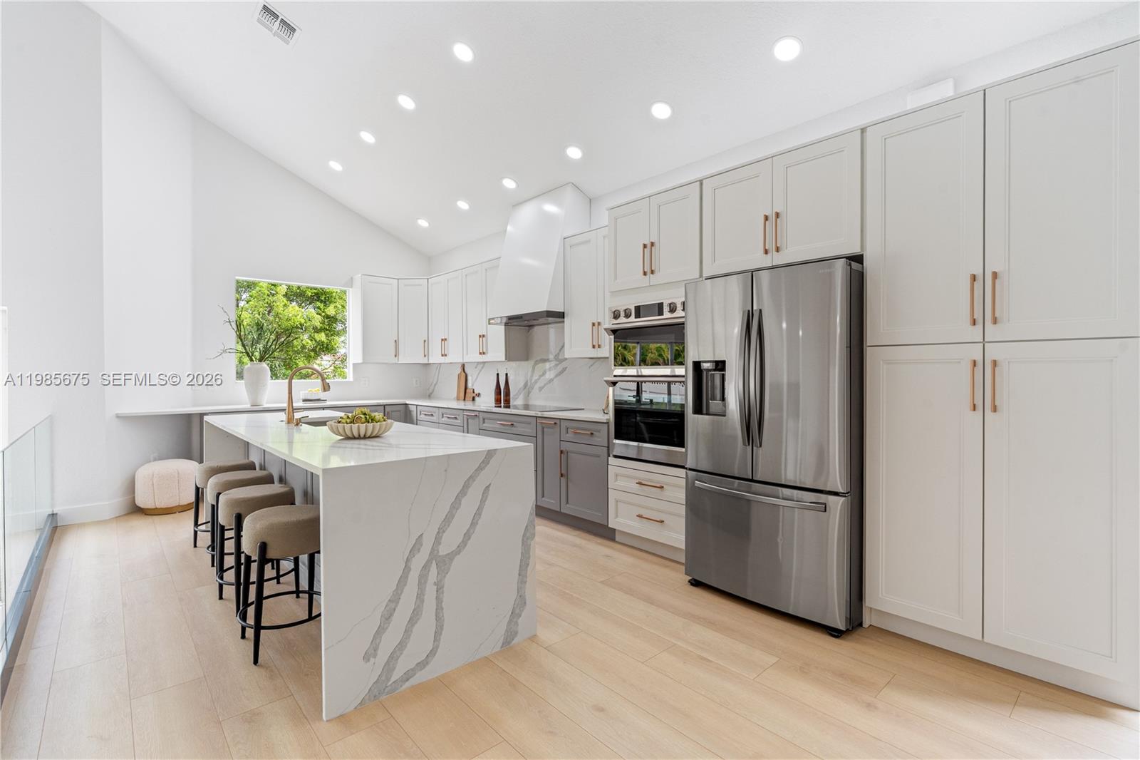 9840 Stover Way Wellington, FL 33414 - Photo 10 of 23 a kitchen with kitchen island white cabinets and stainless steel appliances
