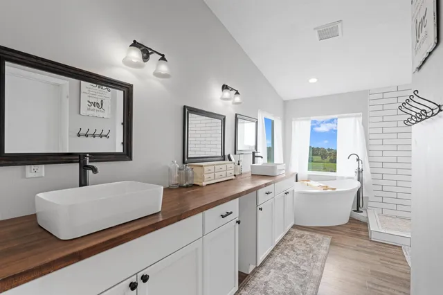 a kitchen with kitchen island granite countertop a sink a stove a refrigerator cabinets and wooden floor