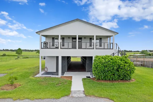 a front view of a house with yard and green space
