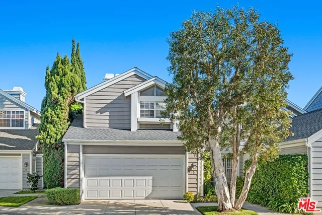 a front view of a house with a tree