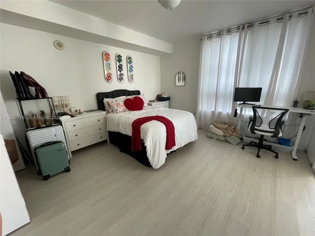 a spacious bedroom with a bed and a furniture