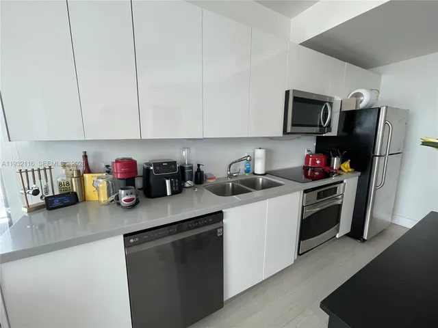 a kitchen with stainless steel appliances granite countertop a sink dishwasher stove top oven and cabinets