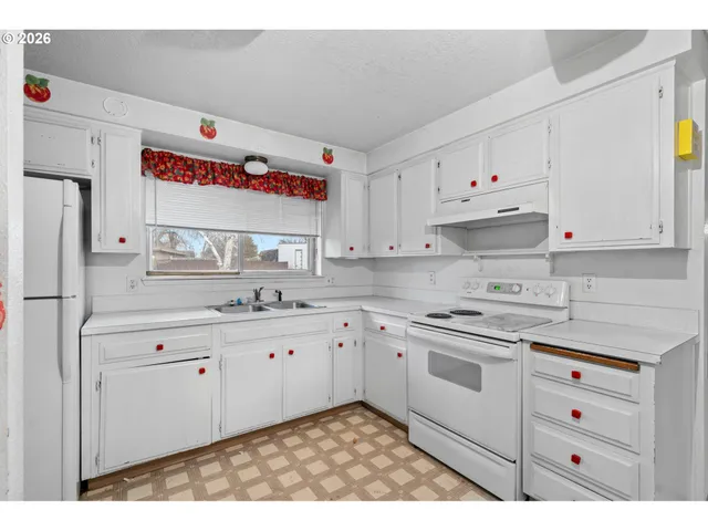 a kitchen with granite countertop white cabinets and white appliances
