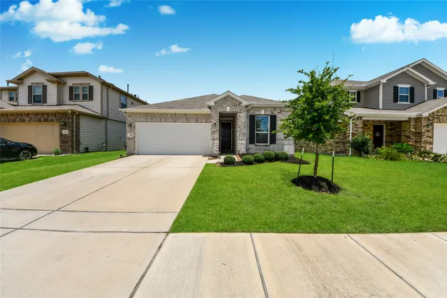 a front view of a house with a yard and trees