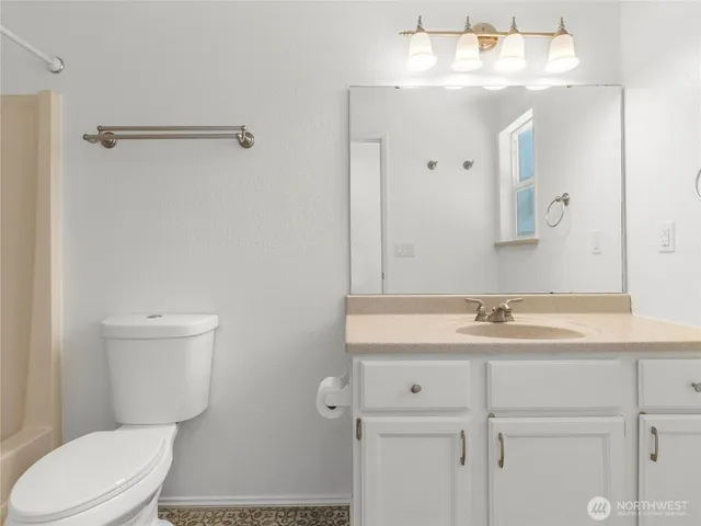 a bathroom with a sink a toilet a mirror and vanity