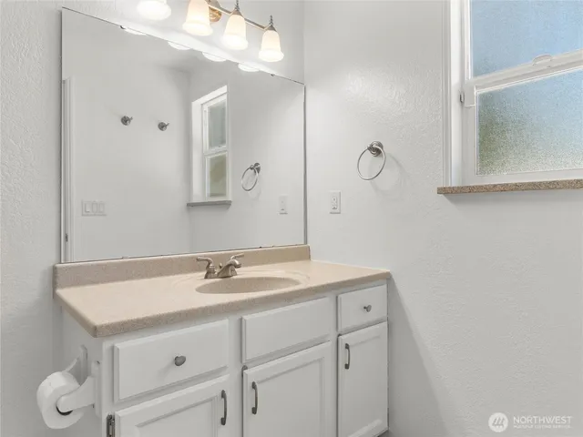 a bathroom with a sink vanity and a mirror