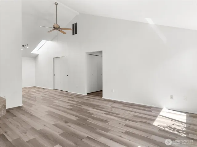 a view of a room with wooden floor and a ceiling fan