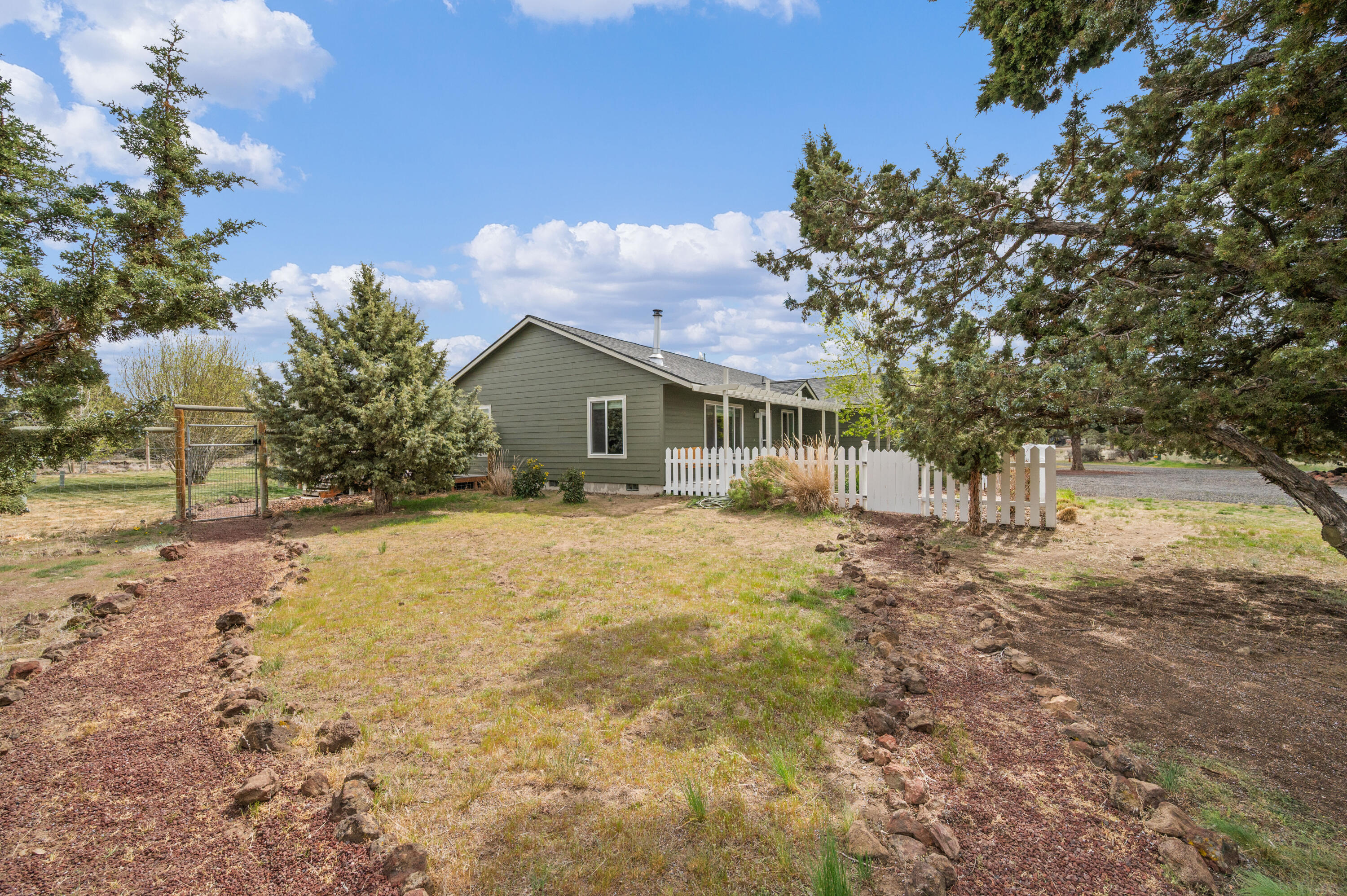 16625 Southwest Dove Road Terrebonne, OR 97760 - Photo 5 of 50 a backyard of a house with table and chairs under an umbrella