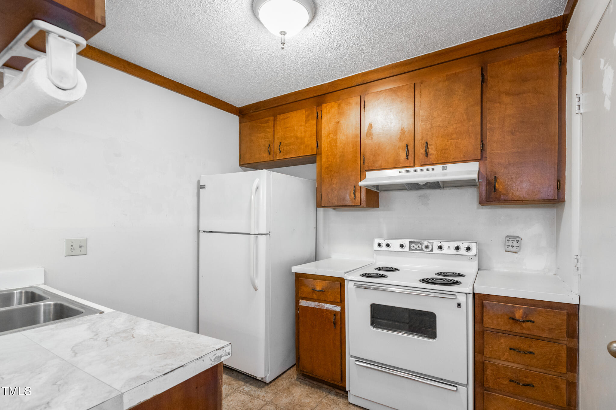 1809-1811 Quail Ridge Road Raleigh, NC 27609 - Photo 23 of 32 a kitchen with a stove a sink and a refrigerator