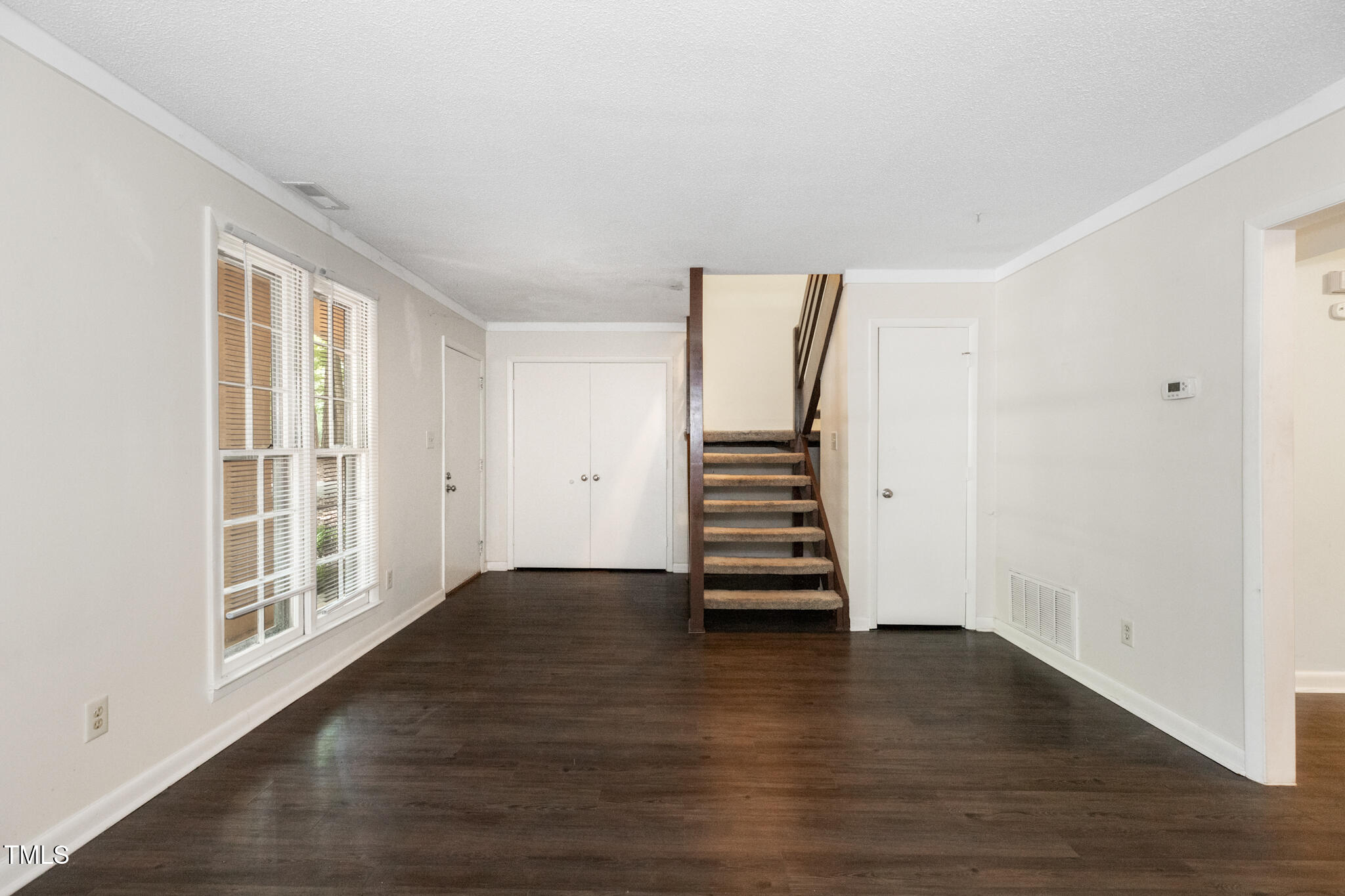 1809-1811 Quail Ridge Road Raleigh, NC 27609 - Photo 5 of 32 an empty room with wooden floor and windows