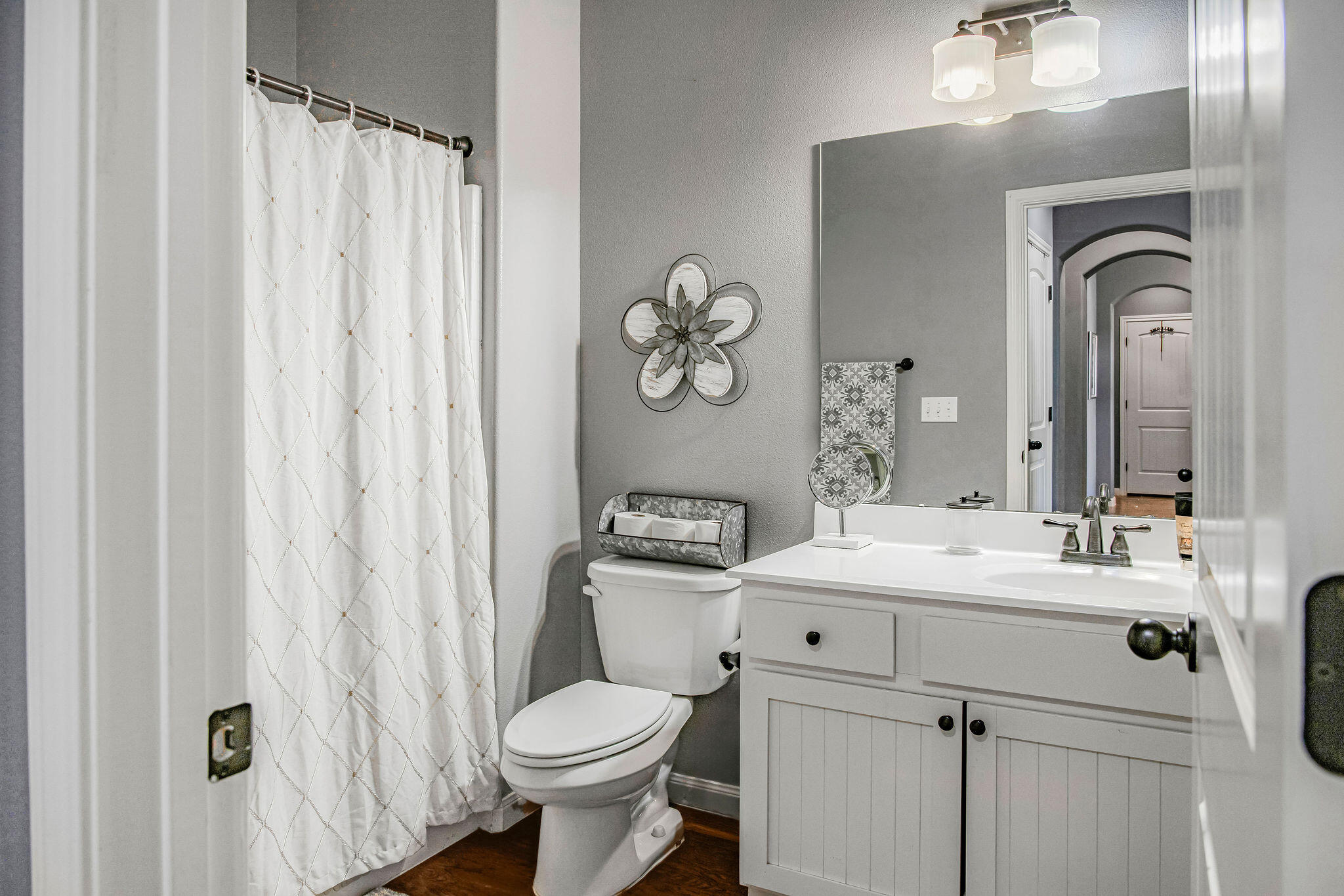 10117 Chicago Avenue Lubbock, TX 79424 - Photo 21 of 36 a bathroom with a sink a toilet and a mirror