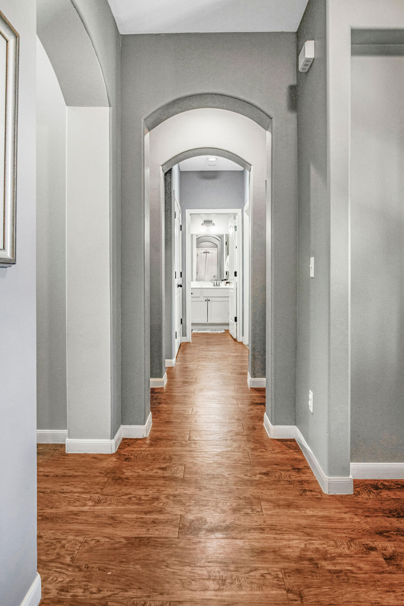 10117 Chicago Avenue Lubbock, TX 79424 - Photo 10 of 36 a view of a hallway with wooden floor and a bathroom