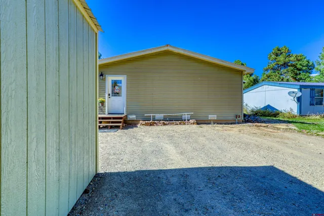 a view of a house with a yard plants and a car parked