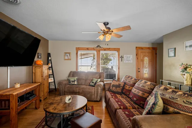 a kitchen with stainless steel appliances granite countertop a stove and a view of living room