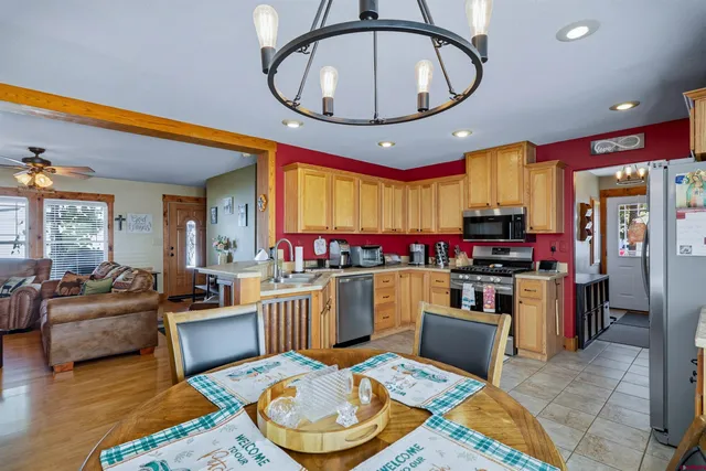a living room with furniture a chandelier and a dining table