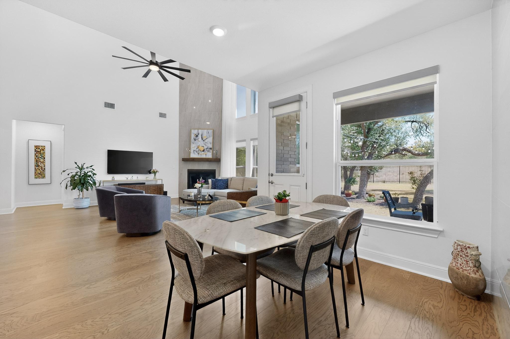 249 Running Bird Road Austin, TX 78737 - Photo 12 of 40 Breakfast dining space with light wood finished floors, a high ceiling, ceiling fan, and a fireplace