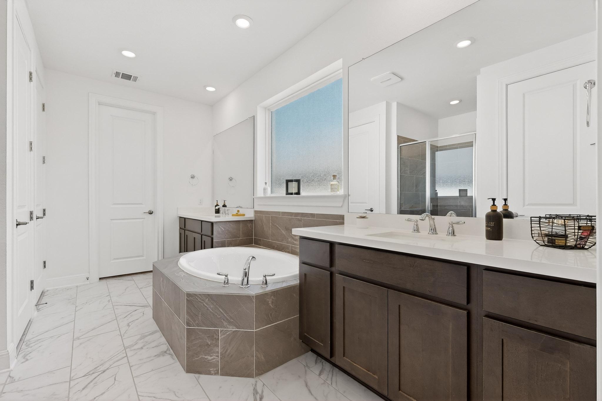 249 Running Bird Road Austin, TX 78737 - Photo 18 of 40 Primary Bathroom with two vanities, a shower stall, a bath, recessed lighting, and light marble finish floors