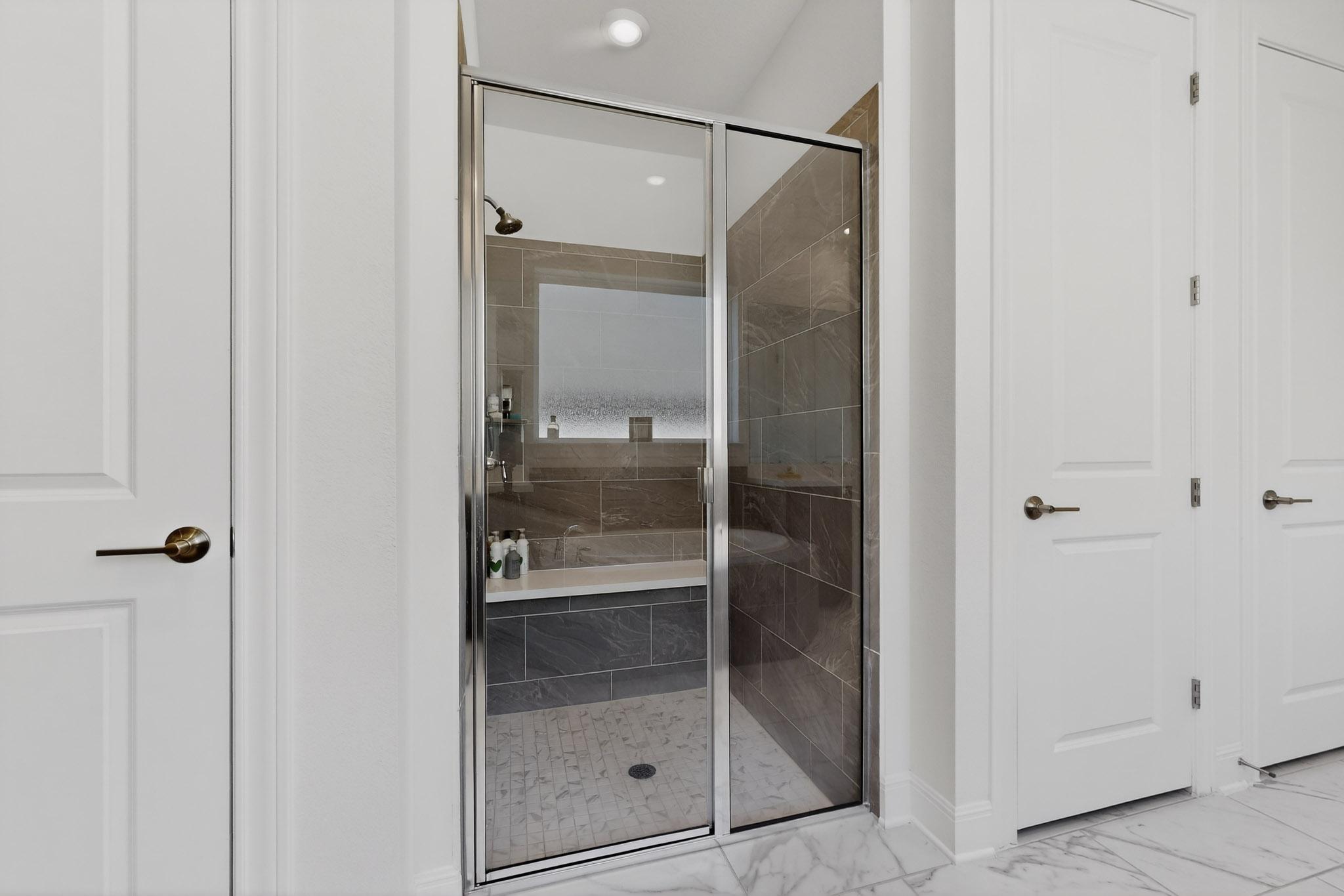 249 Running Bird Road Austin, TX 78737 - Photo 19 of 40 Primary Bathroom featuring a stall shower, recessed lighting, light marble finish flooring, and a closet