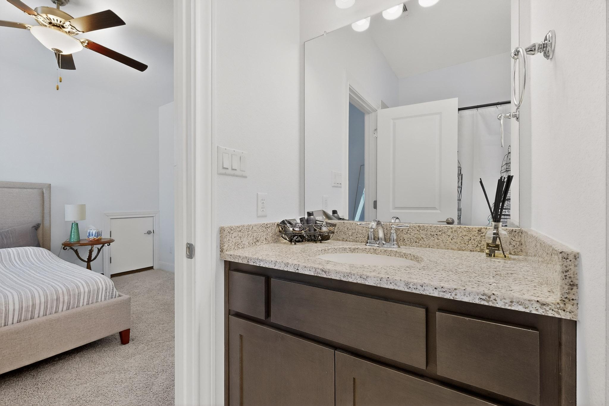 249 Running Bird Road Austin, TX 78737 - Photo 22 of 40 Ensuite bathroom featuring vanity, light colored carpet, a shower with curtain, and ceiling fan