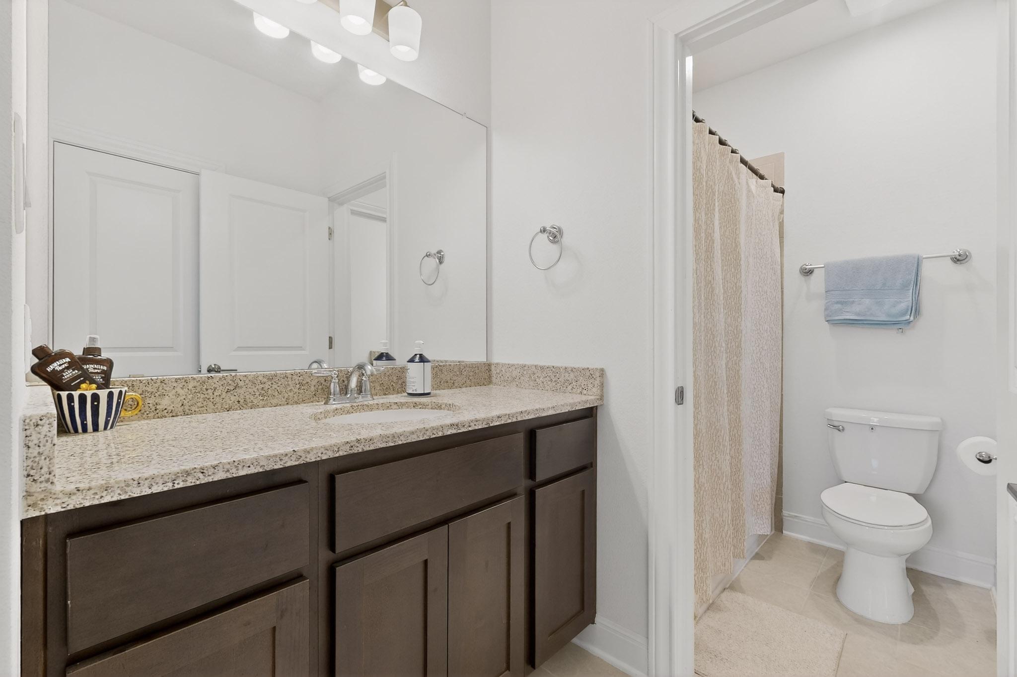249 Running Bird Road Austin, TX 78737 - Photo 25 of 40 Bathroom with vanity, a shower with curtain, and light tile patterned flooring
