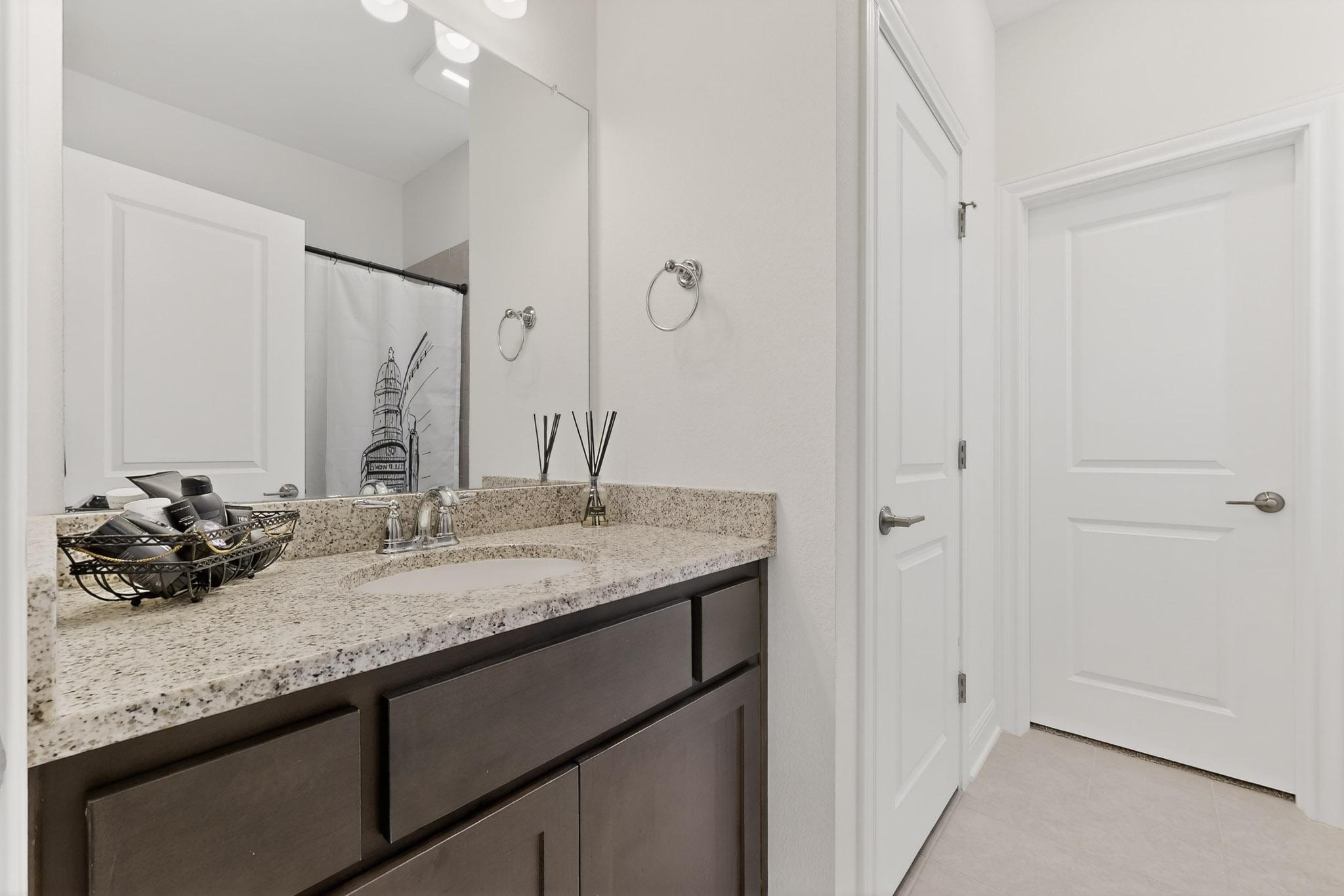 249 Running Bird Road Austin, TX 78737 - Photo 26 of 40 Bathroom with vanity, curtained shower, and light tile patterned flooring