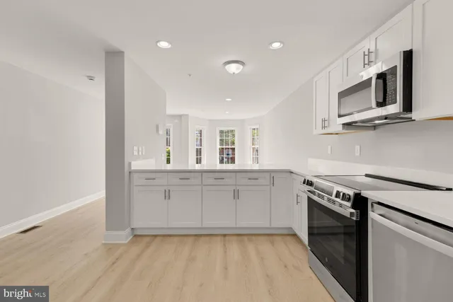 a kitchen with stainless steel appliances cabinets a sink and a microwave