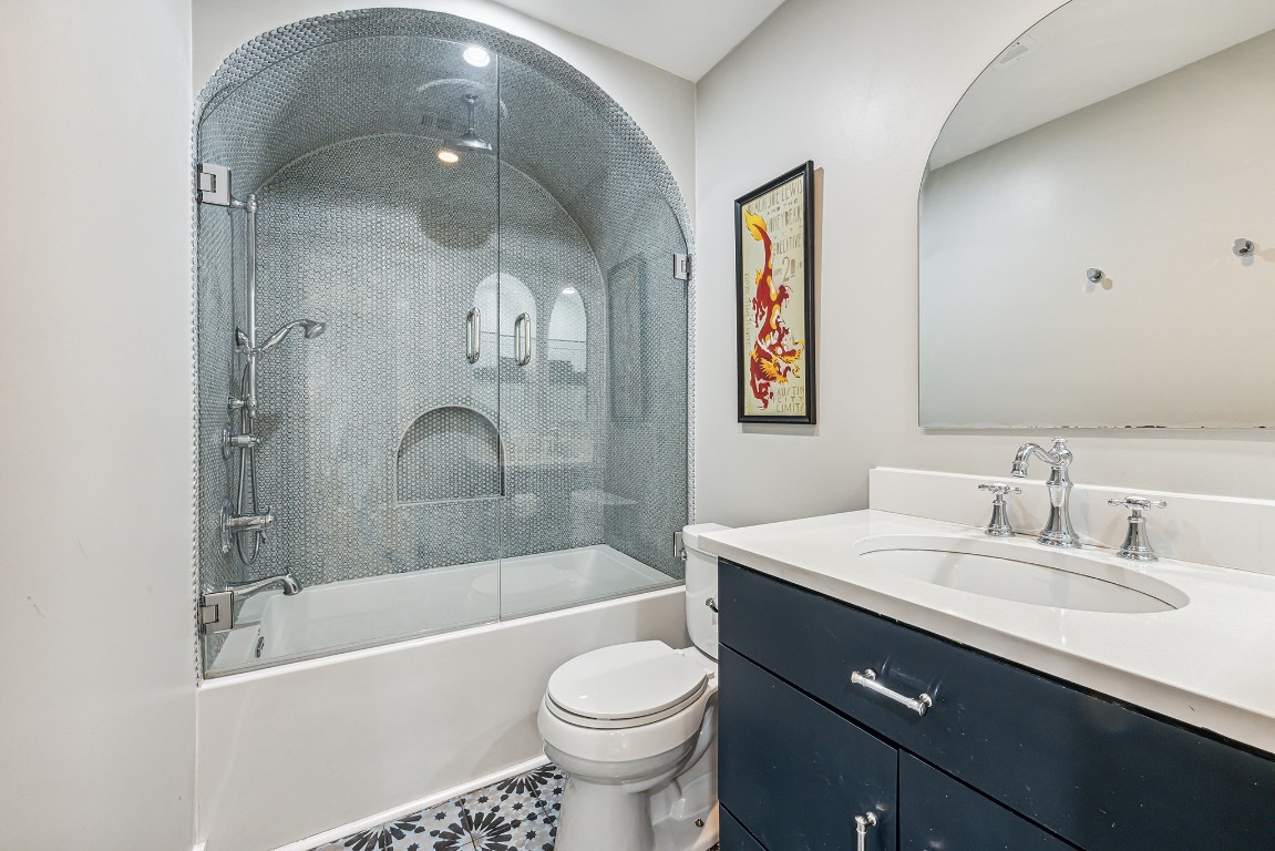 a bathroom with a bathtub shower sink mirror and toilet