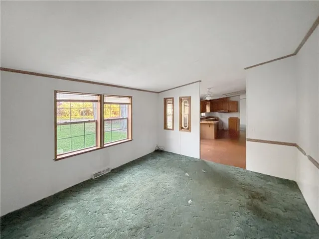 an empty room with a fireplace and large window