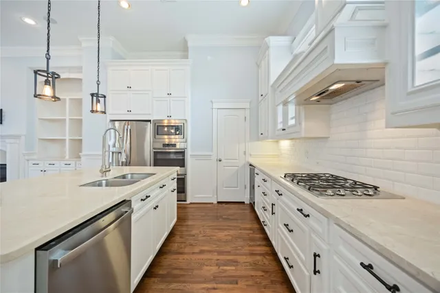 a large kitchen with stainless steel appliances kitchen island granite countertop a lot of counter space and wooden floors
