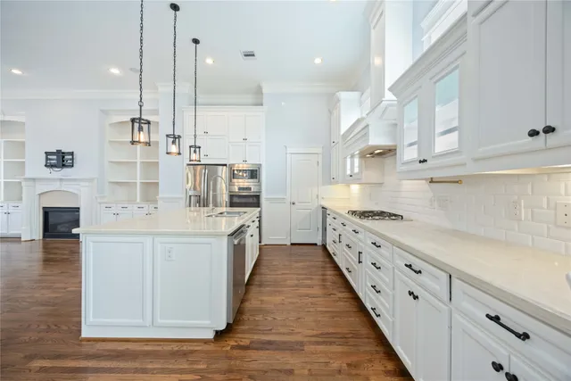 a large white kitchen with cabinets