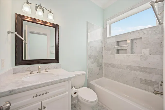 a bathroom with a granite countertop sink a toilet and bathtub