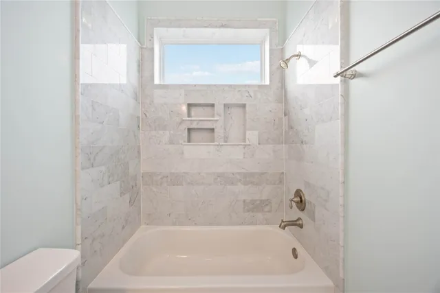 a bath tub sitting next to a white sink and a toilet