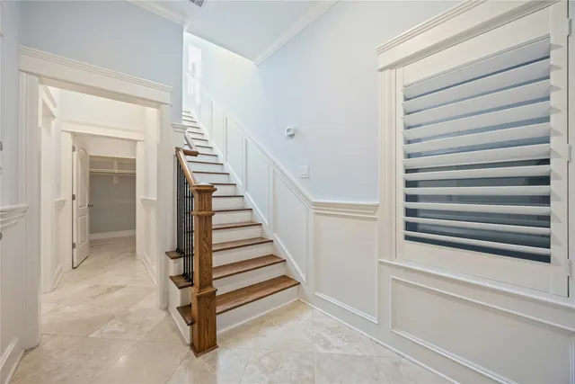 a view of a hallway with stairs and a cabinet