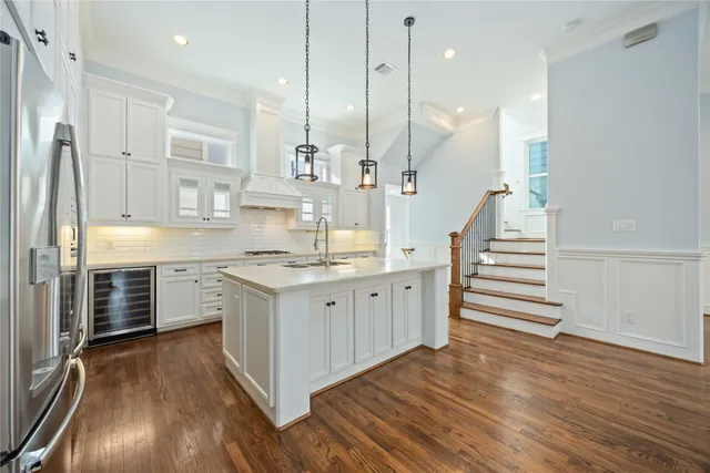a kitchen with stainless steel appliances sink stove and wooden floor