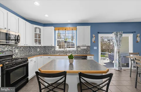 a dining area with stainless steel appliances kitchen island granite countertop a dining table chairs and granite counter tops