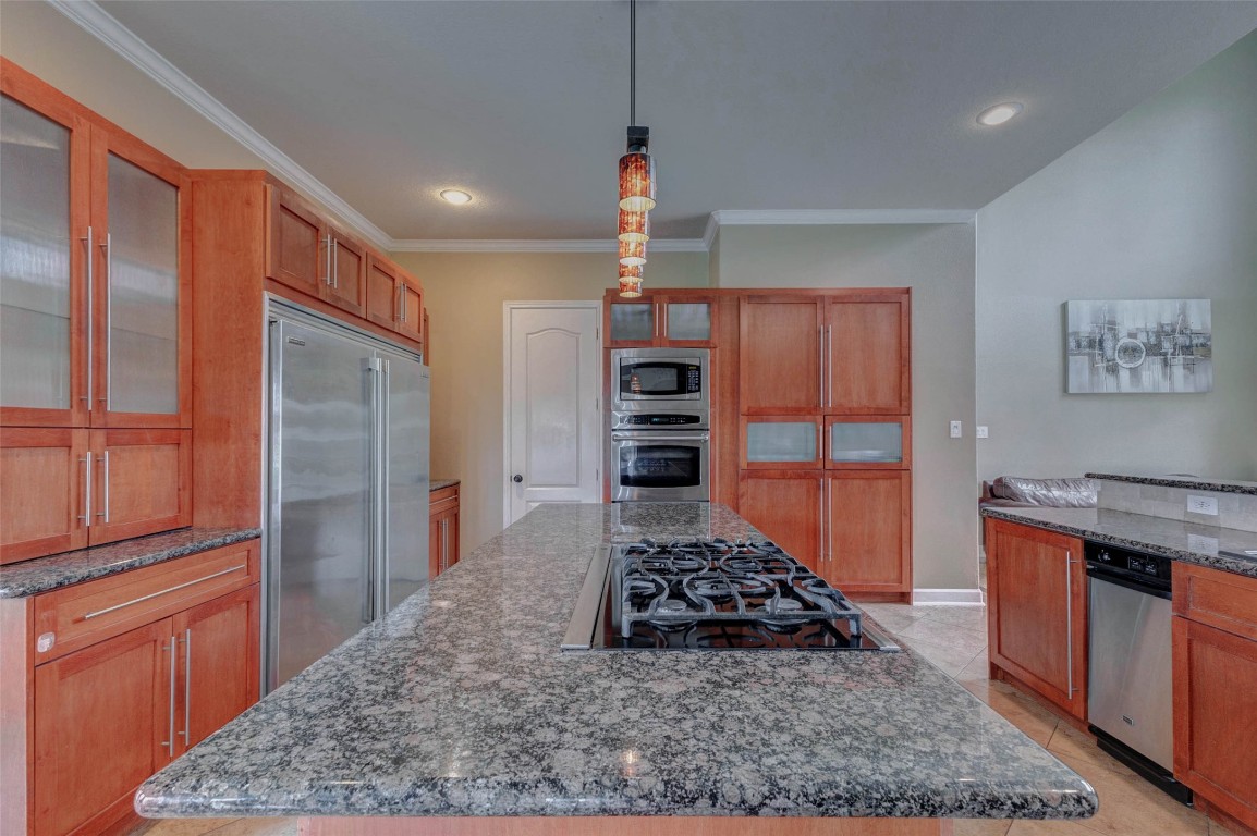5610 Westerham Weston Lakes, TX 77441 - Photo 13 of 47 Large center island features a gas cooktop and stylish pendant lighting, complemented by double ovens with a built in microwave. You also have crown molding and recessed lighting.