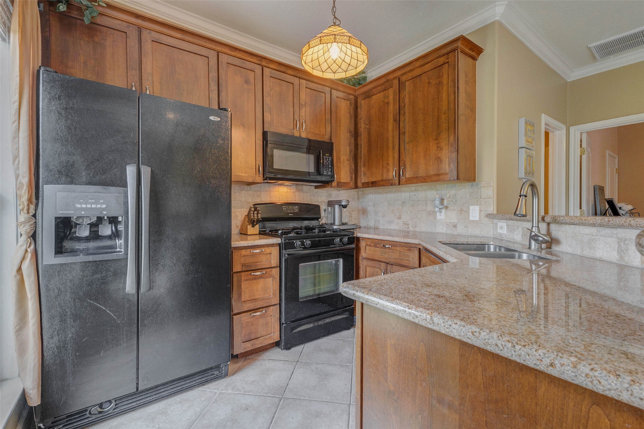 5610 Westerham Weston Lakes, TX 77441 - Photo 37 of 47 a kitchen with stainless steel appliances granite countertop a refrigerator a stove and a sink