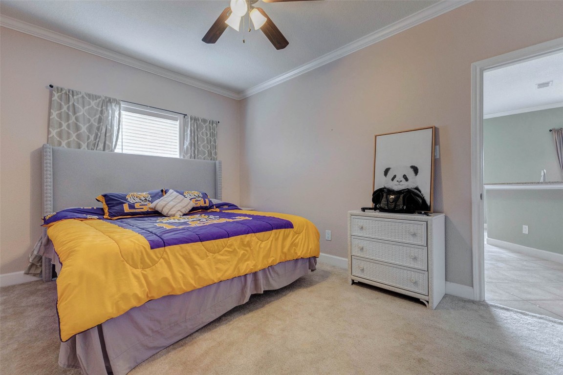 5610 Westerham Weston Lakes, TX 77441 - Photo 38 of 47 a bedroom with a bed and a chandelier