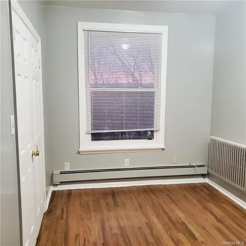 a view of a room with wooden floor and a window