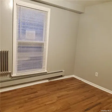 a view of a small space with wooden floor and a window