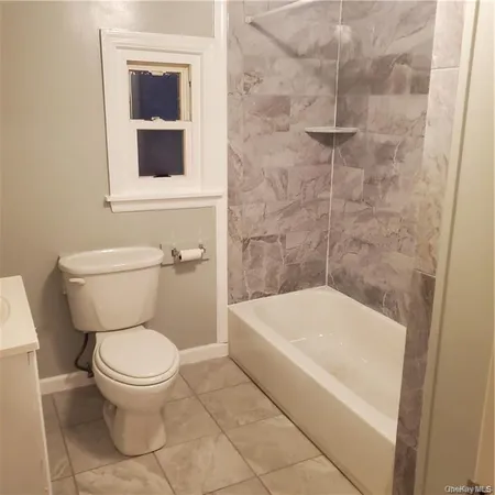 a white toilet sitting next to a white tub