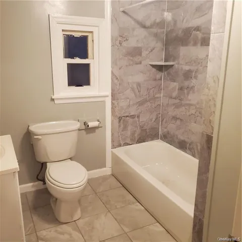 a white toilet sitting next to a white tub