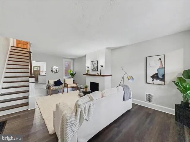 a living room with furniture a fireplace and wooden floor
