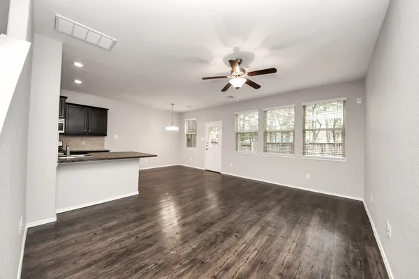 a view of empty room with wooden floor and ceiling fan