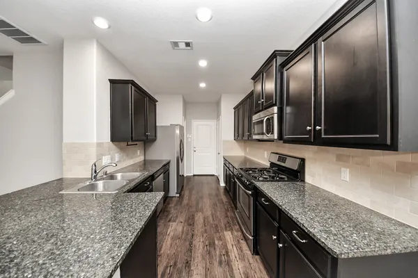 a kitchen with granite countertop a stove and a sink