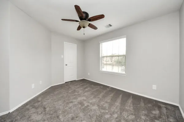 an empty room with chandelier fan
