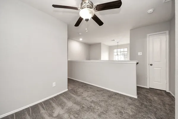 wooden floor in an empty room and a ceiling fan