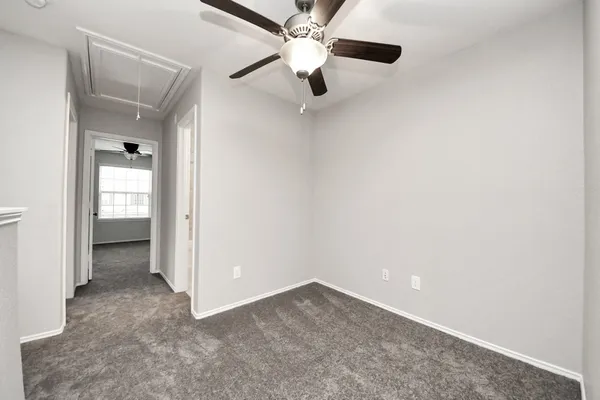 an empty room with window and ceiling fan